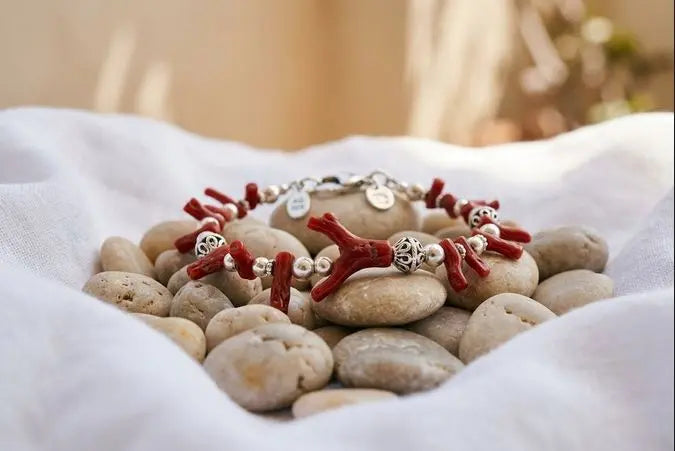 Bracelet en corail rouge de Méditerranée et argent posé sur des galets méditerranéens, bijouterie Marc-Ricca Porticcio, Corse-du-Sud
